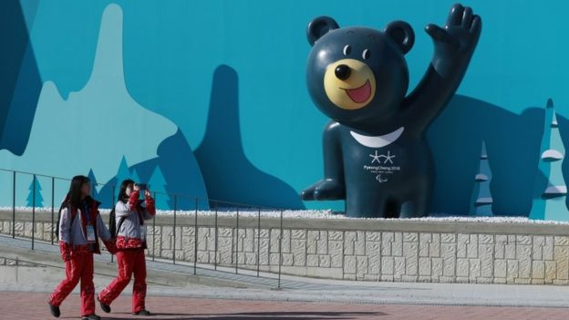 Voluntarias pasan frente a una escultura de una mascota de las Olimpiadas de Invierno en el Parque Olímpico Gangneung, en Gangneung, Corea del Sur.