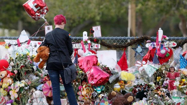 A Marjory Stoneman Douglas High School student stops to look at one of the memorials following their return to school in Parkland, Florida on February 28, 2018