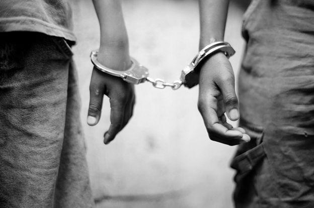 A close-up of kids wearing handcuffs