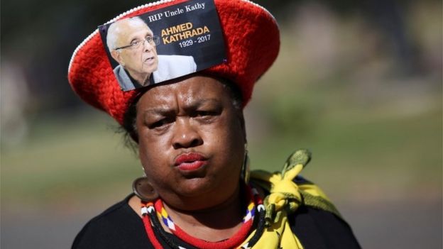 A mourner arrives wearing a hat bearing a picture of Ahmed Kathrada, who was sentenced to life imprisonment alongside Nelson Mandela, during his funeral at the Westpark Cemetery in Johannesburg, South Africa, March 29, 2017.