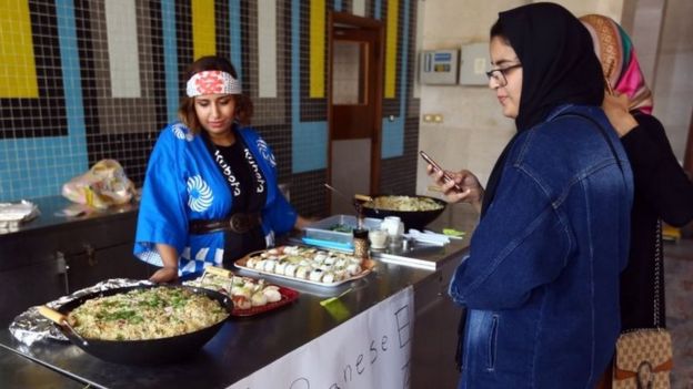 Libyans stand at a Japanese food stall during the Libya Comic Convention (02 November 2017)