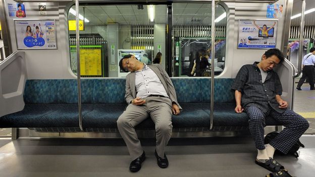 Dos pasajeros en Tokio toman una siesta en el metro.