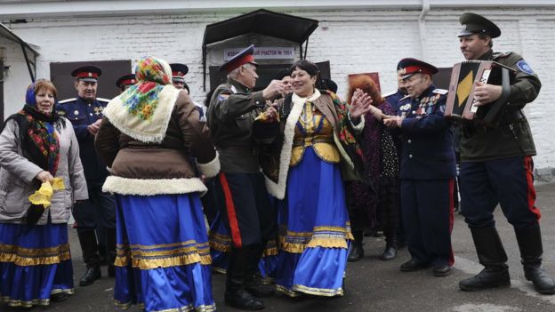Members of a local Cossack community dance outside a polling station during the presidential election in Rostov-on-Don