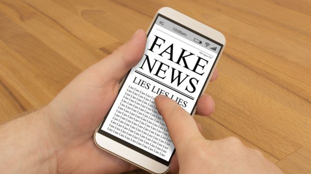 Celular com ilustração de fake news