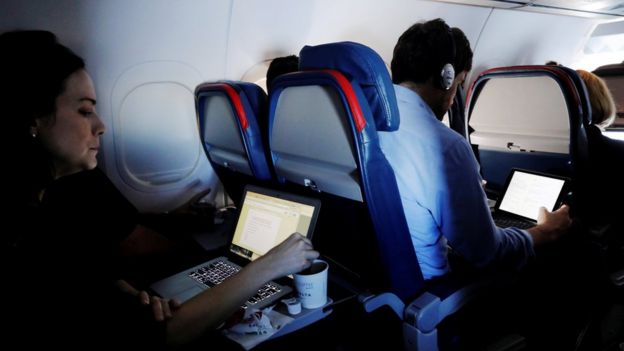 Pasajeros con laptops en un avión