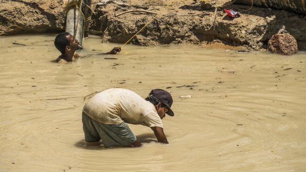 Trabajadores en una mina de oro laboran en agua sucia en la región Mazaruni, Guyana