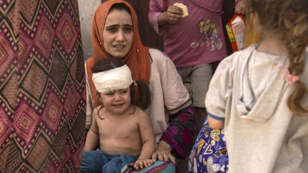 Una mujer con una niña herida en Mosul