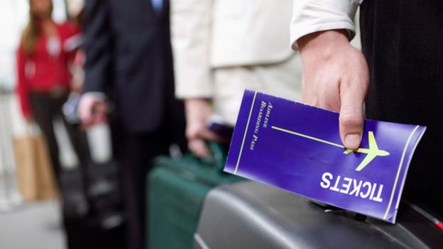 hombre sosteniendo billete de avión