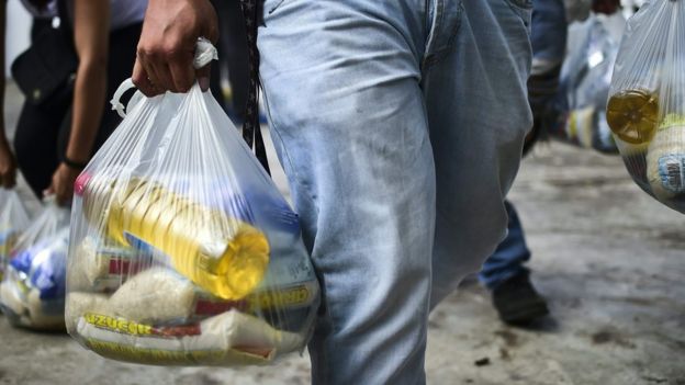 Una persona que lleva una bolsa de comida