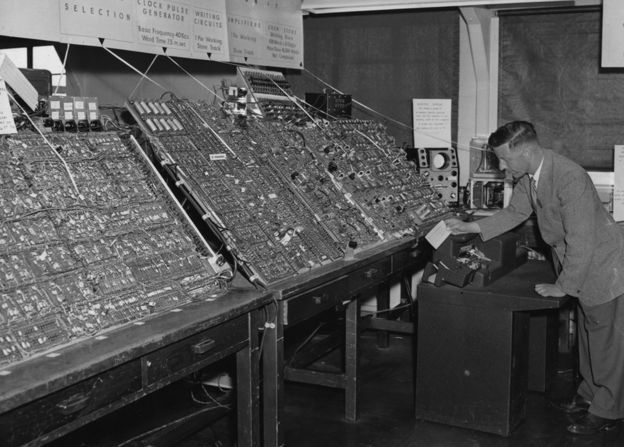 Man using a massive computer in 1956