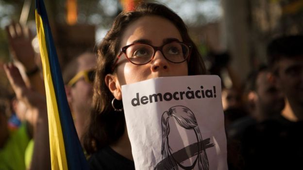 Mujer con cartel pidiendo democracia en Cataluña.