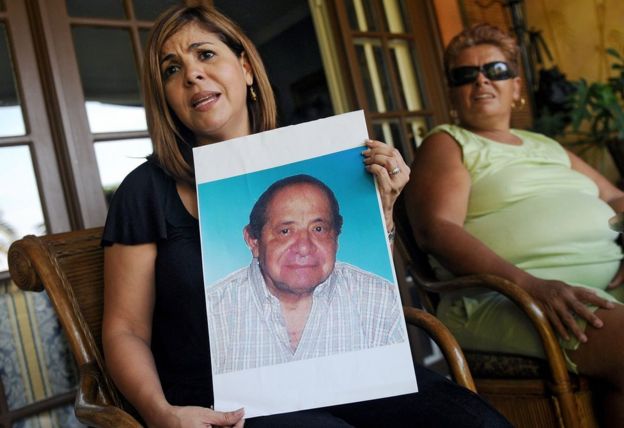Mitzila Donado (izquierda), junto a su madre Rudecinda Delgado, sostiene una foto de su padre, Jaime Donaldo, quien murió en 2006 tras haber tomado el "jarabe de la muerte". Imagen tomada el 25 de marzo de 2009 en Ciudad de Panamá. (Foto: Elmer Martínez / AFP / Getty Images)