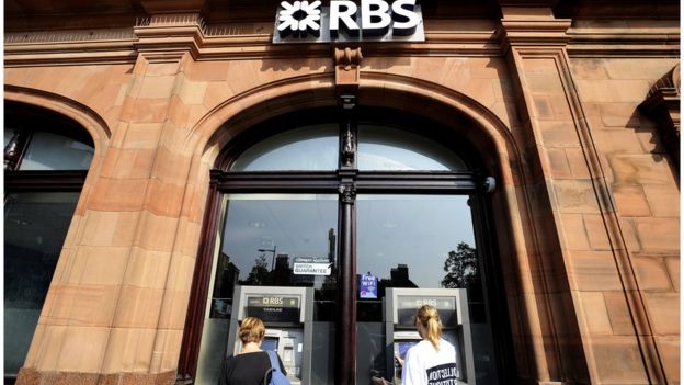 Two women use cash machines at an RBS branch
