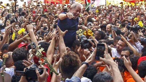 Lula da Silva arropado por cientos de seguidores.