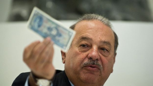 Carlos Slim muestra un billete.