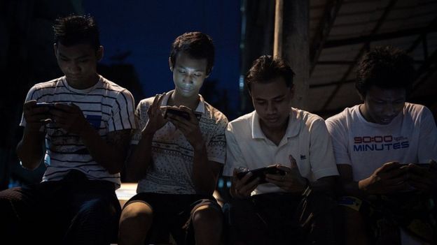 Personas consultan sus celulares en Camboya.