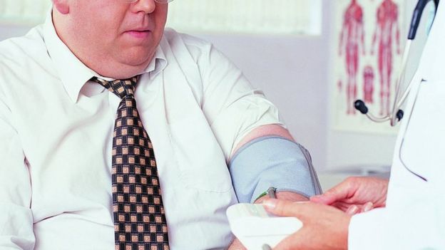 Homem obeso tem a pressão arterial medida