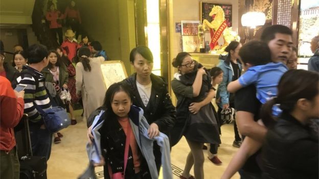 Tourists leave a hotel in in Ruo'ergai, Sichuan