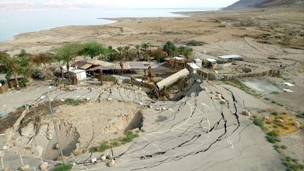 Imagen de carretera destrozada por socavón.