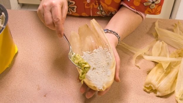 Una mujer prepara tamales