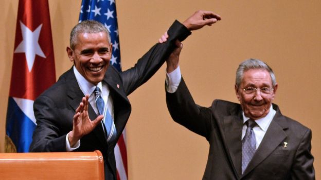 El presidente cubano, Raúl Castro, levanta la mano de su par estadounidense, Barack Obama.