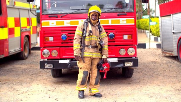 Kenyan firefighter in front of fire engine
