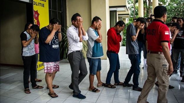 This photo taken on April 30, 2017 shows Indonesian police parading a group of men arrested for allegedly holding a 'gay party' in Surabaya, the second biggest city in Indonesia, the world's most populous Muslim-majority country. Officers busted 14 men holding the party in two hotel rooms in Surabaya, around midnight on April 29.