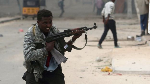 Somali government soldiers run to take their positions during gunfire after an attack at a hotel in Mogadishu on 25 June