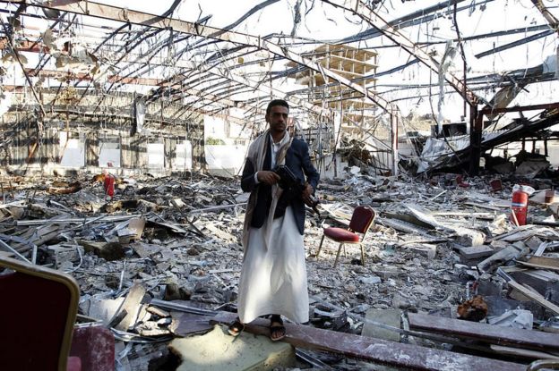 Un hombre yemení en pie y armado en el escenario de un ataque aéreo que tuvo lugar en Yemen el 5 de octubre de 2016, durante un funeral y en el que murieron 140 personas y resultaron heridas 525.