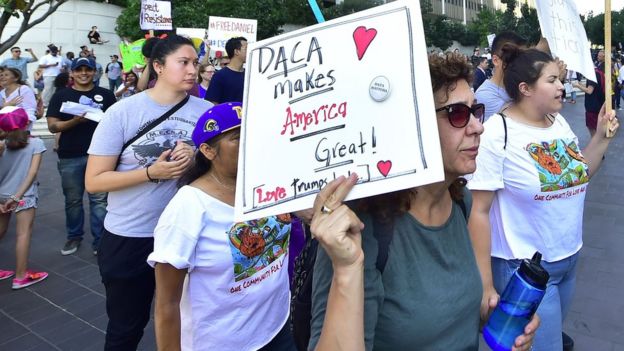 Young immigrants and supporters walk holding signs during a rally in support of Daca in Los Angeles, on September 1, 2017