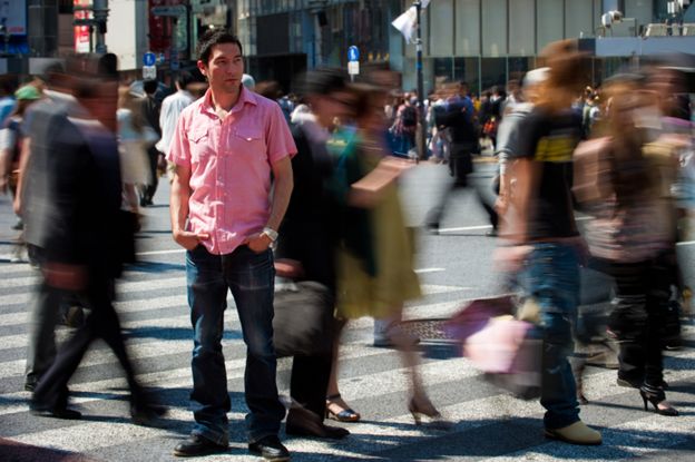 Un hombre solo en una ciudad llena de gente.