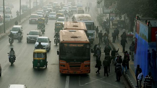 Buses y autos en una calle india con el aire contaminado