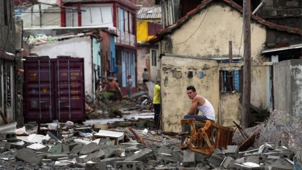 Un hombre sentado sobre los escombros en Baracao