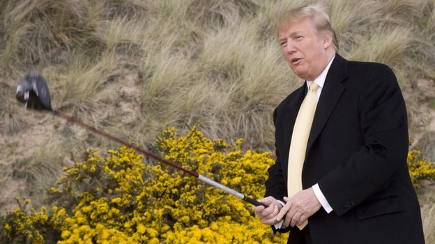 Trump com um taco de golfe