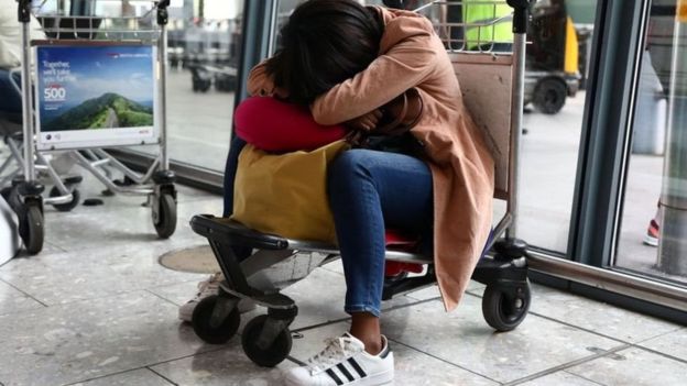 سيدة تغطي وجهها في مكان عام