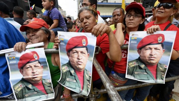 Supporters of President Nicolás Maduro hold posters of former President Hugo Chávez during a demonstration in Caracas on August 3, 2013.