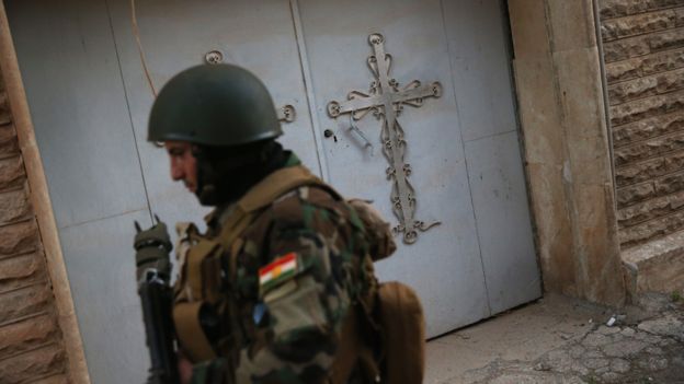 A Christian militiaman patrols through the abandoned Assyrian streets of Telskuf on 4 November, 2015 near the frontline with ISIS fighters in Telskuf, northern Iraq.