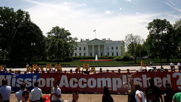 لافتة ومتظاهرون أمام البيت الأبيض