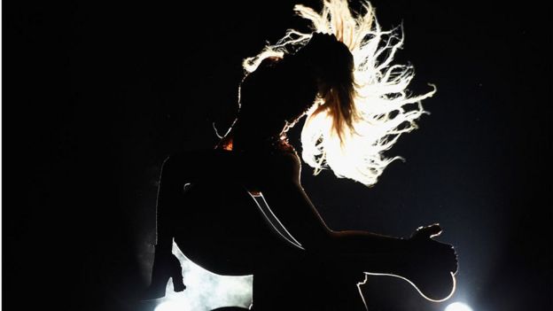 Contraluz de Beyonce en medio de un concierto. Su cabello se agita al viento.