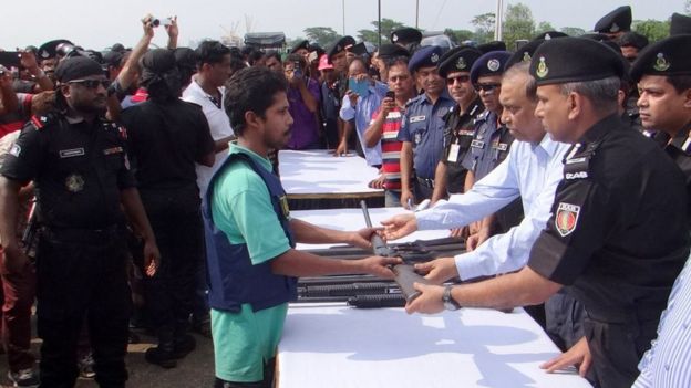 স্বরাষ্ট্রমন্ত্রী আসাদুজ্জামান খাঁনের কাছে অস্ত্র সমর্পণ করছে একজন জলদস্যু।