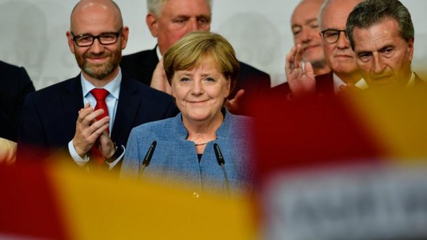 German Chancellor and Christian Democrat (CDU) Angela Merkel (C) reacts to initial results