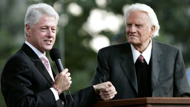 Former U.S. President Bill Clinton speaks along with Billy Graham during Graham's Crusade at Flushing Meadows Corona Park June 25, 2005