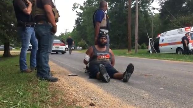 Suspect Cory Godbolt handcuffed, and sat on the ground, after being detained by police