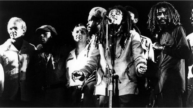 Bob Marley cantando al lado de su banda
