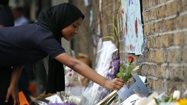 Children lay flowers in tribute to the victims of a van attack in the Finsbury Park area of north London.