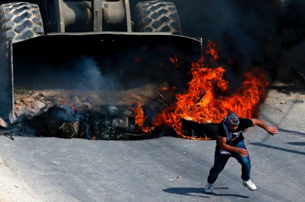 Manifestante palestino huye de un tractor de Israel.