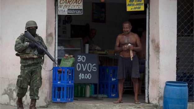 Militar ao lado de homem em bar na Vila Kennedy