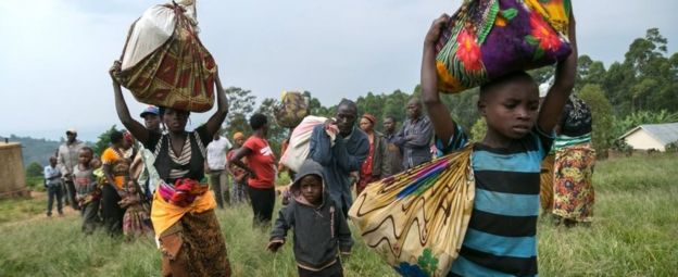 Congolese people carry their belongings as they cross border from the Democratic Republic of Congo to Nteko village in western Uganda on January 24, 2018.