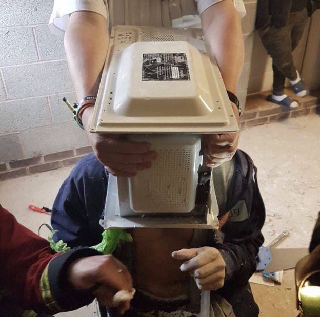 The microwave on the man's head