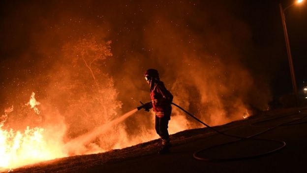 A firefighter tries to extinguish a fire in Cabanoes near Louzan as wildfires continue to rage in Portugal on October 16, 2017